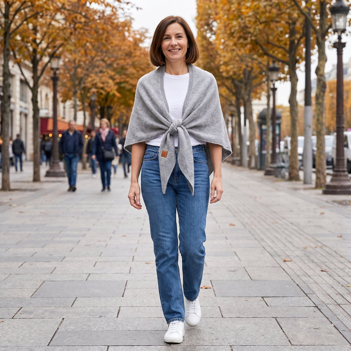 Frau mit Jeans und hellgrauem Tuch in der Stadt